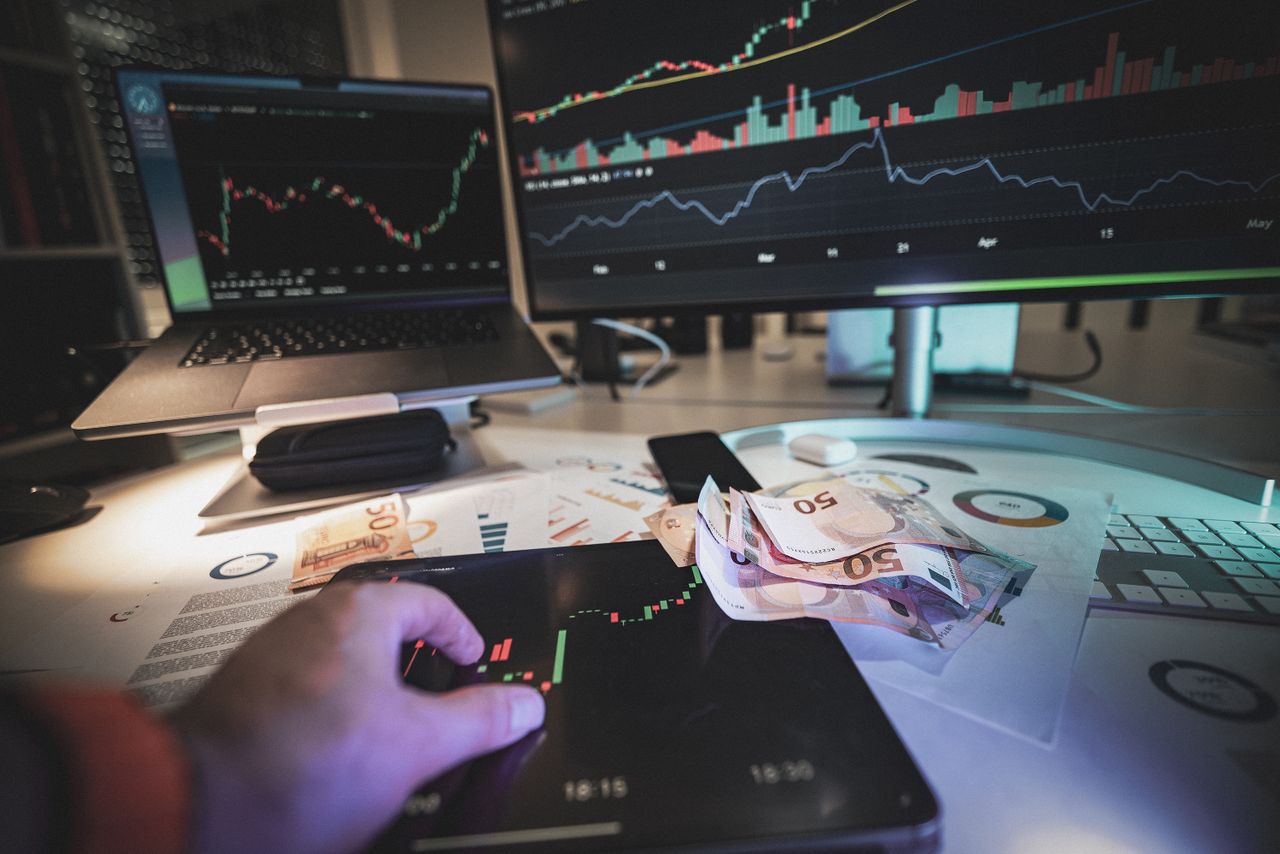 Home A modern trading desk with screens showing market charts and euro notes, capturing a trading atmosphere.