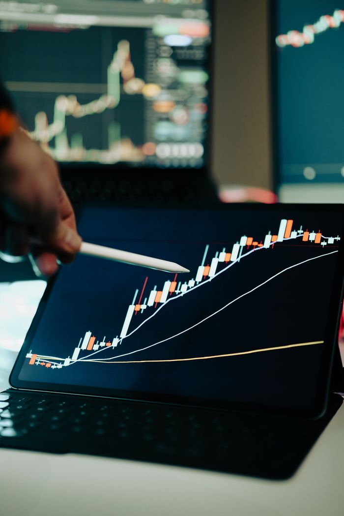 Services Close-up of a digital tablet showing a financial growth chart with graphs and trends under analysis.